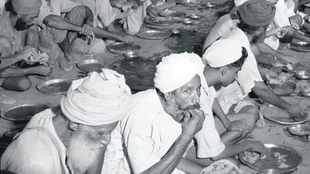 Sikh refugees dey chop free food for di ground for relief camp for Amritsar for 1947/1948.