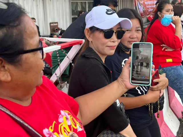 นางลาวัลย์ ศิริวงศ์พาณิช อายุ 60 ปี จากจังหวัดบุรีรัมย์กำลังชมคลิปที่ น.ส. ยิ่งลักษณ์มาส่งพี่ชายที่สนามบินในสิงคโปร์