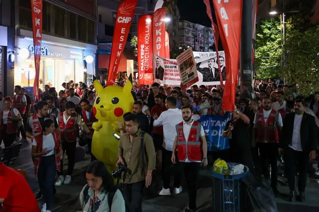 Pikachu kostümlü bir katılımcının da olduğu göstericiler miting öncesi yürüyüş yapıyor.