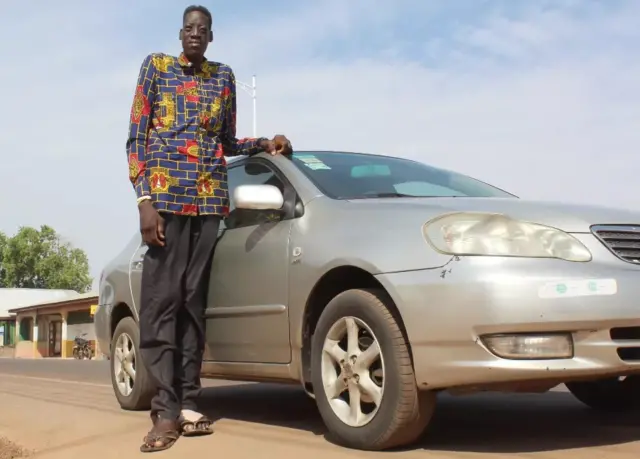 Awuche près d'une voiture.