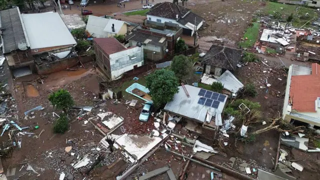 Foto aérea mostra casas destruídas e rodeadas de lama