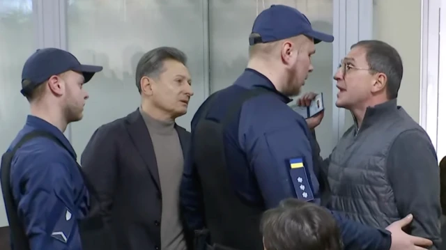 Депутат "Батьківщини" Костянтин Бондарєв із криками та образами у бік суду демонструє своє посвідчення представникам Соужби судової охорони. Поруч із ним ще один депутат "Батьківщини" Михайло Волинець