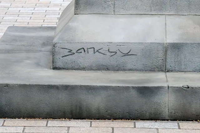 heykelin altındaki platformda banksy'nin imzası 