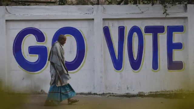 ২০২৪ সালের পাঁচই জানুয়ারি সাধারণ নির্বাচনের আগে একজন ব্যক্তি রাস্তায় হাঁটছেন