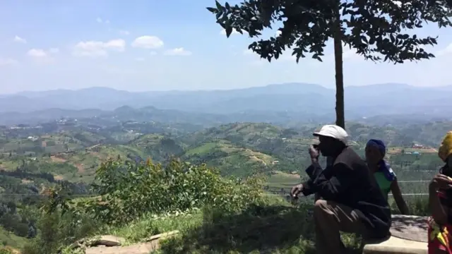 A man looks over hills in Rwanda