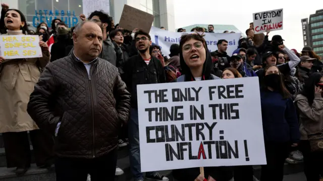 دختر پلاکارد به دست در حال فریاد میان جمعیت