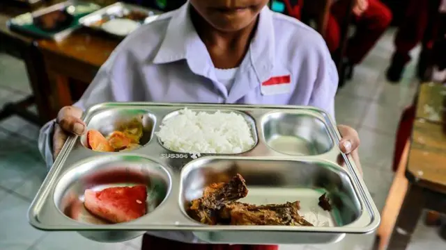 Siswa menunjukkan menu makanan bergizi gratis di Madrasah Ibtidaiyah Negeri 2 Kota Ternate, Maluku Utara, Senin (6/1/2025).