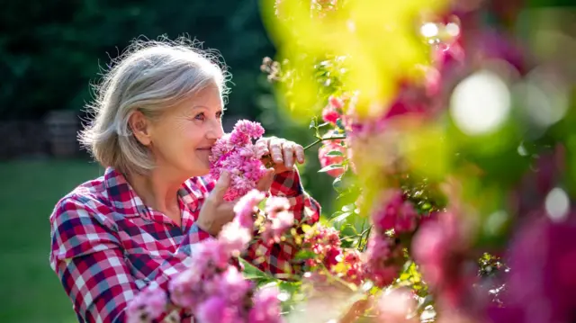 Жінка нюхає квіти
