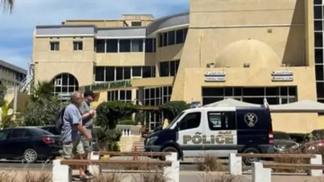 ljudi i policijski auto ispred bolnice