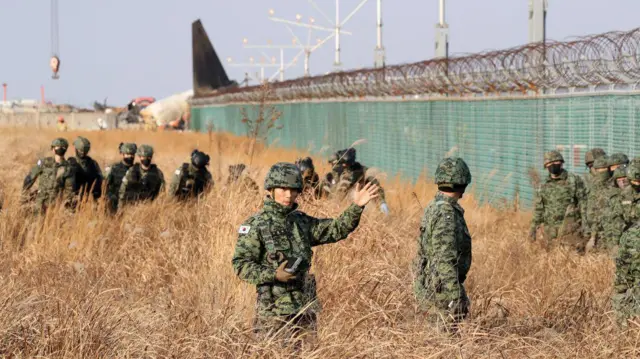 आसपास के इलाक़े की जांच करते सैनिक