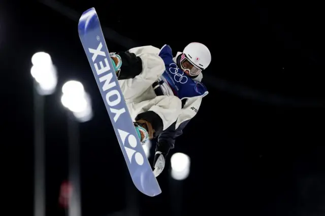 白いウエアの戸塚が、空中でボードを立てるようにして飛んでいる