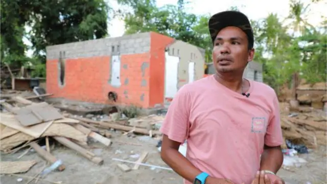 Damar di depan puing-puing yang dulu rumahnya