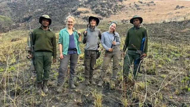 Исследователи с геологическими инструментами и охранники с винтовками в дикой местности