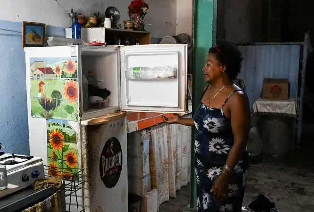Une mujer mira dentro de su refrigerador