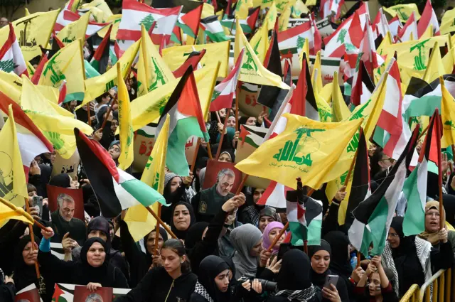Supporters of Hezbollah wave Palestinian