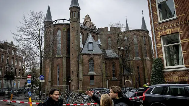 Kilisenin yangında büyük hasar aldığı görülüyor. Dışarısındaki üç kişi birbirlerine bir şeyler anlatıyor