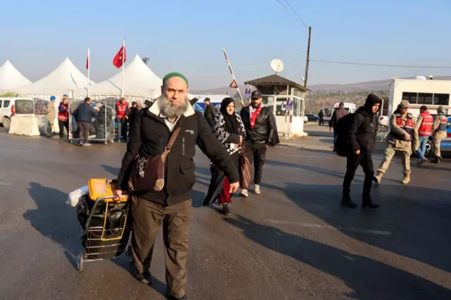 17 Aralık'ta, Hatay'daki Cilvegözü sınır kapısından ülkelerine geçen Suriyeliler. Ellerinde bavullar var. 
