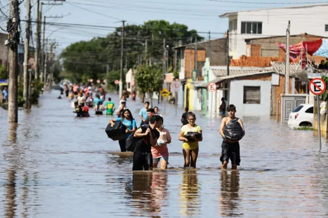 Fotografia mostra pessoas andandotelegram pixbetrua alagada