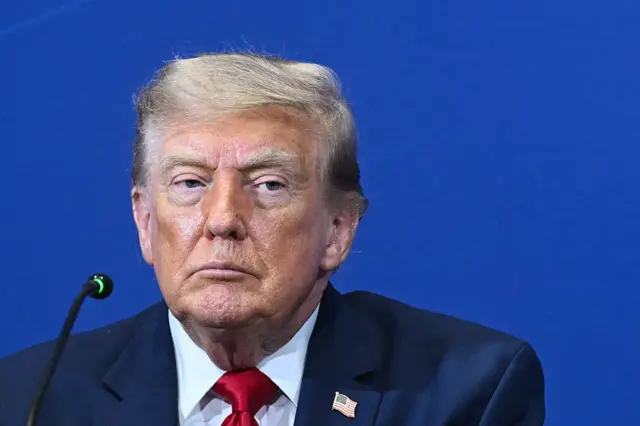 Trump usando um terno azul e gravata vermelha