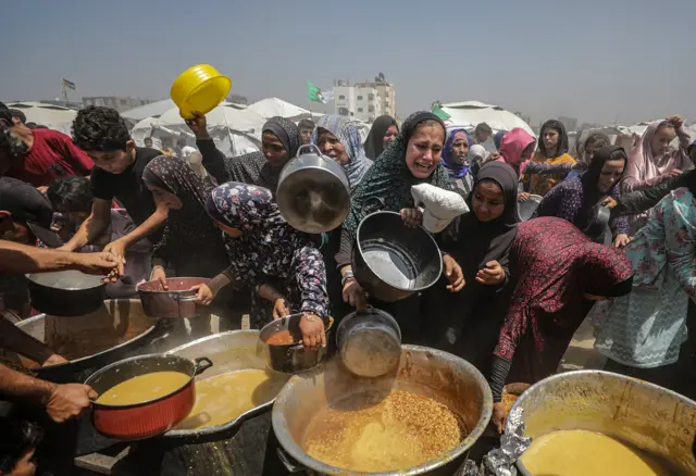 نازحون فلسطينيون يحاولون الحصول على الطعام في مخيم جباليا للاجئين، شمال قطاع غزة