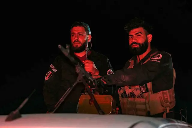 أفراد من قوات الأمن السورية يحرسون نقطة تفتيش عند مدخل جرمانا بالقرب من دمشق