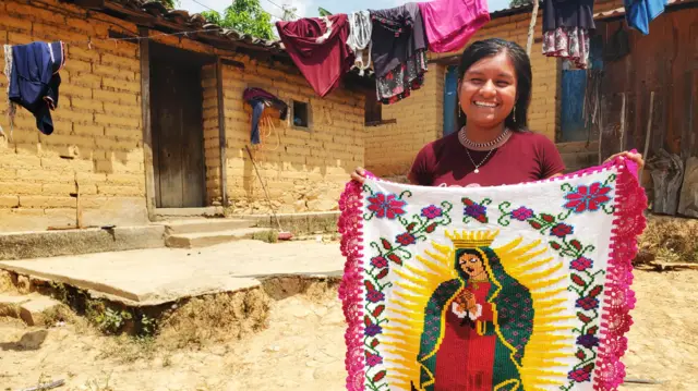 Fotografia colorida mostra jovem mexicana segundo uma tapeçaria com imagemcasas de apostas com aposta gratisnossa senhora