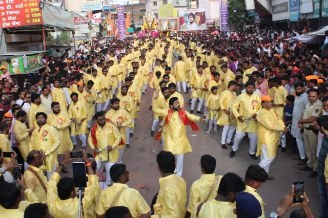 विसर्जन मिरवणुकीत लेझीम वाजवणारे नागरिक