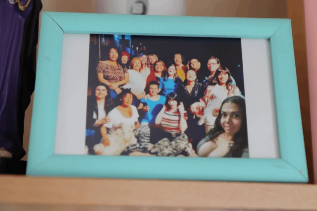 Fotografía de un retrato donde se ve una fotografía de un grupo de mujeres trans junto a Astorga.