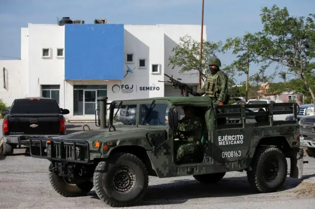 Carro militar com soldado e arma no topo