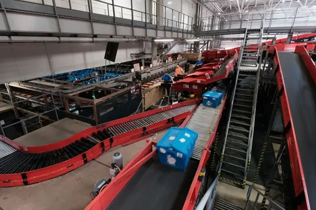 Блакитна посилка на червоній чортувальній доріжці на пошті