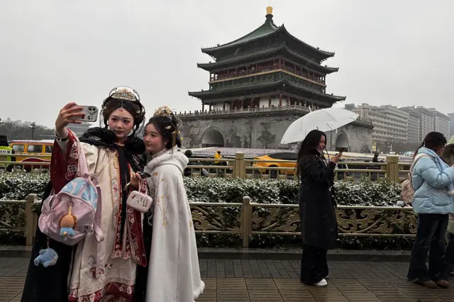 Hai người phụ nữ trong trang phục truyền thống đang chụp hình ở Tháp chuông Tây An, địa điểm du lịch nổi tiếng ở tỉnh Thiểm Tây, Trung Quốc