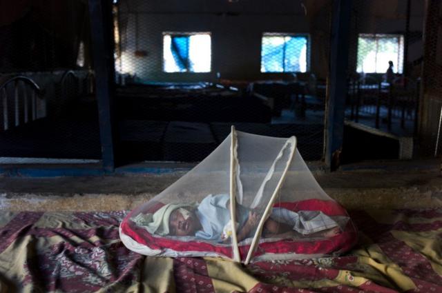 طفل يعاني من سوء التغذية ينام داخل ناموسية للحماية من الملاريا داخل مستشفى تابع للصليب الأحمر في دولة جنوب السودان.