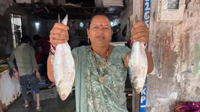 અન્ય એક મહિલા માછીમારના હાથમાં હિલ્સા માછલી 