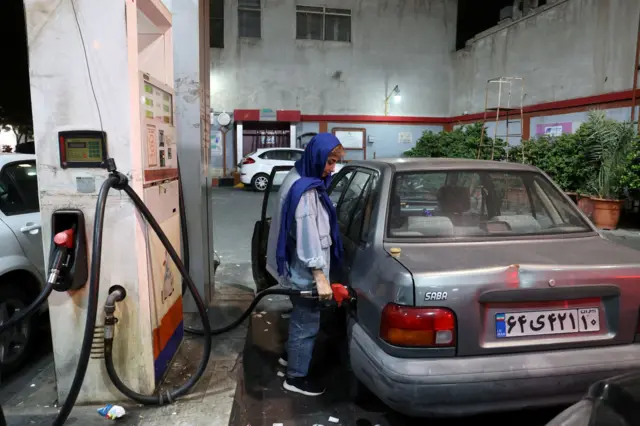 İran'da İsrail'e düzenlenen saldırıların arıdndan arabasına benzin dolduran bir kadın