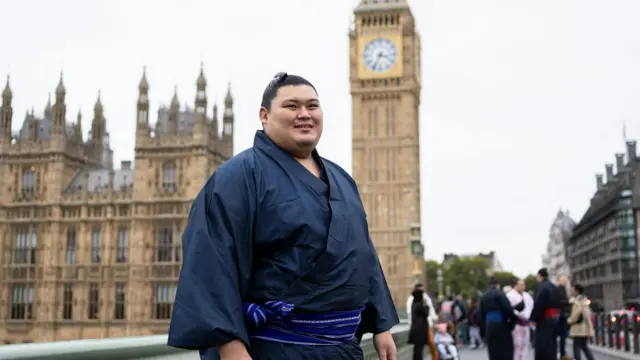 ロンドンの国会議事堂の時計塔を背景に、大の里が笑顔で立っている