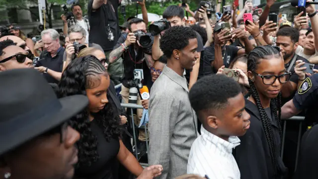 Trois personnes traversent une foule de caméras