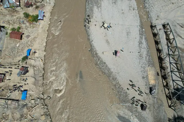 Foto udara kondisi jembatan yang menghubungkan dua desa telah hancur.