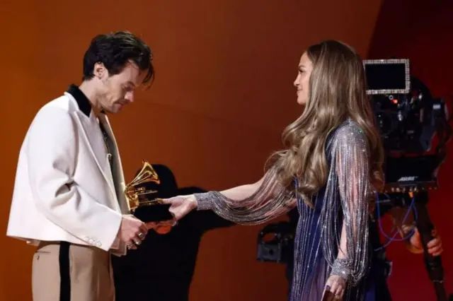 Jennifer Lopez entregando Grammy a Harry Styles