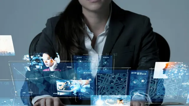 Seorang perempuan menonton video di layar.