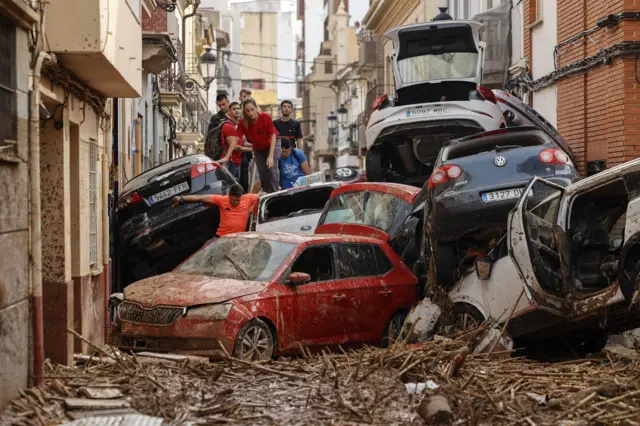 Um gruporeal bet casino aviatorjovens sobe numa pilha carros arrastados pelas cheias na vilareal bet casino aviatorPaiporta