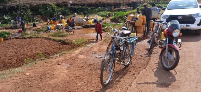 Abariko baravoma amazi yo rusengo mu mwonga uri hepfo y'ihoteri Accolade i Gitega, n'amakinga apakiyeko ibibido, Gitega, Mukakaro 2025