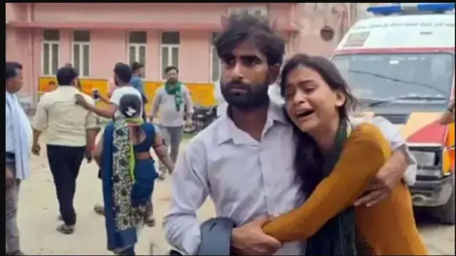 Ọmọbinrin kan n sunkun, ọkunrin kan di i mu