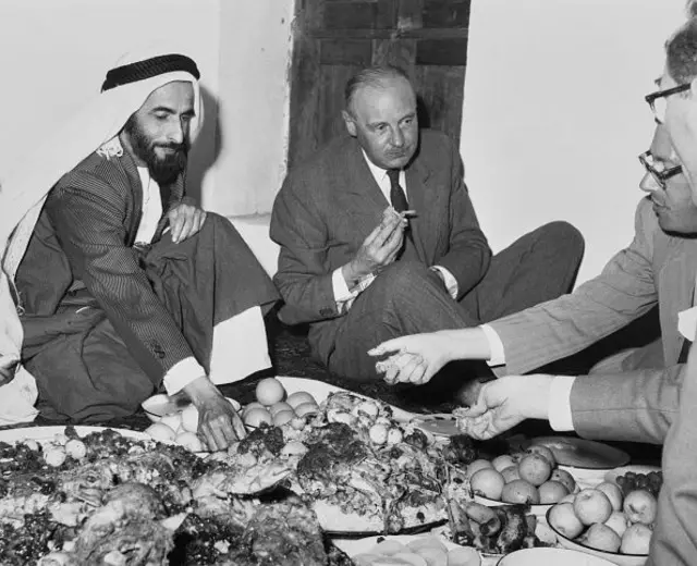 Sheikh Shakhbut bin Sultan (1905 - 1989), ruler of Abu Dhabi, and Sir Neville Gass (1893 - 1965), chairman of the board of British Petroleum, during a luncheon given by the Sheikh at his palace, Abu Dhabi, April 1st 1958.