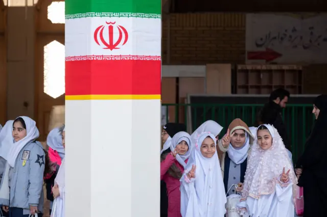 فتيات إيرانيات يرفعن علامة النصر في مرقد فاطمة معصومة، شقيقة الإمام الرضا، في قم، إيران، في 7 فبراير 2024.