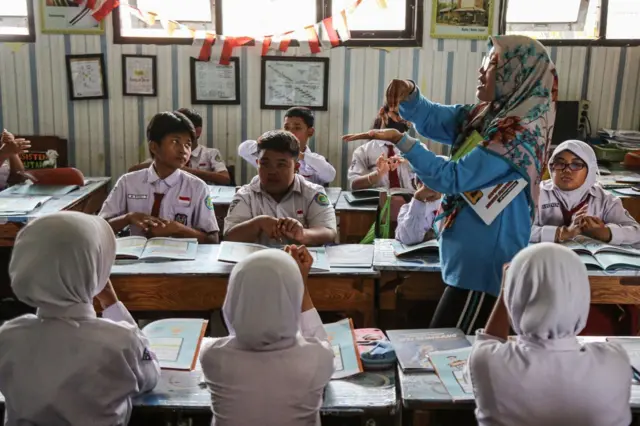 Guru sedang mengajar di kelas
