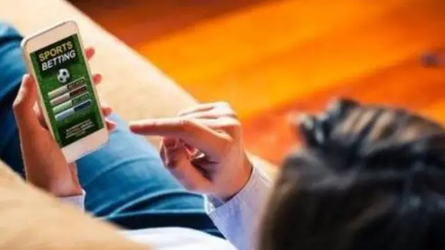 Aworan ẹni to n wo esi tẹtẹ lorii foonu