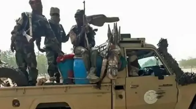 Wasu mayaƙan ƙungiyar riƙe da makamai a cikin motar yaƙi da wasu robobi a cikinta