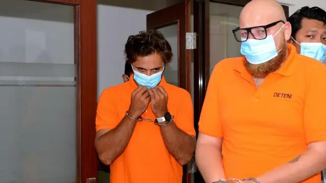 Warga negara Rusia berinisial AG (kanan) dan RK (kiri) digiring petugas saat konferensi pers di Kantor Imigrasi Kelas I Khusus TPI Ngurah Rai, Badung, Bali, Jumat (10/3/2023).