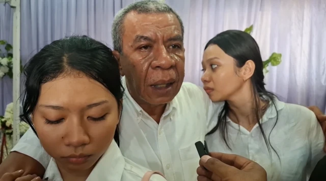 Gabriel Pakaenoni (tengah), ayah dokter Icha bersama kedua putrinya dalam prosesi pemakaman dokter Icha. Ia mengatakan, keluarga selalu diceritakan berulang-ulang oleh dokter Icha tentang kejadian dugaan intimidasi.