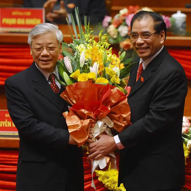 Tại phiên bế mạc Đại hội 11 năm 2011, tân Tổng Bí thư Nguyễn Phú Trọng (trái) được người tiền nhiệm Nông Đức Mạnh tặng hoa 